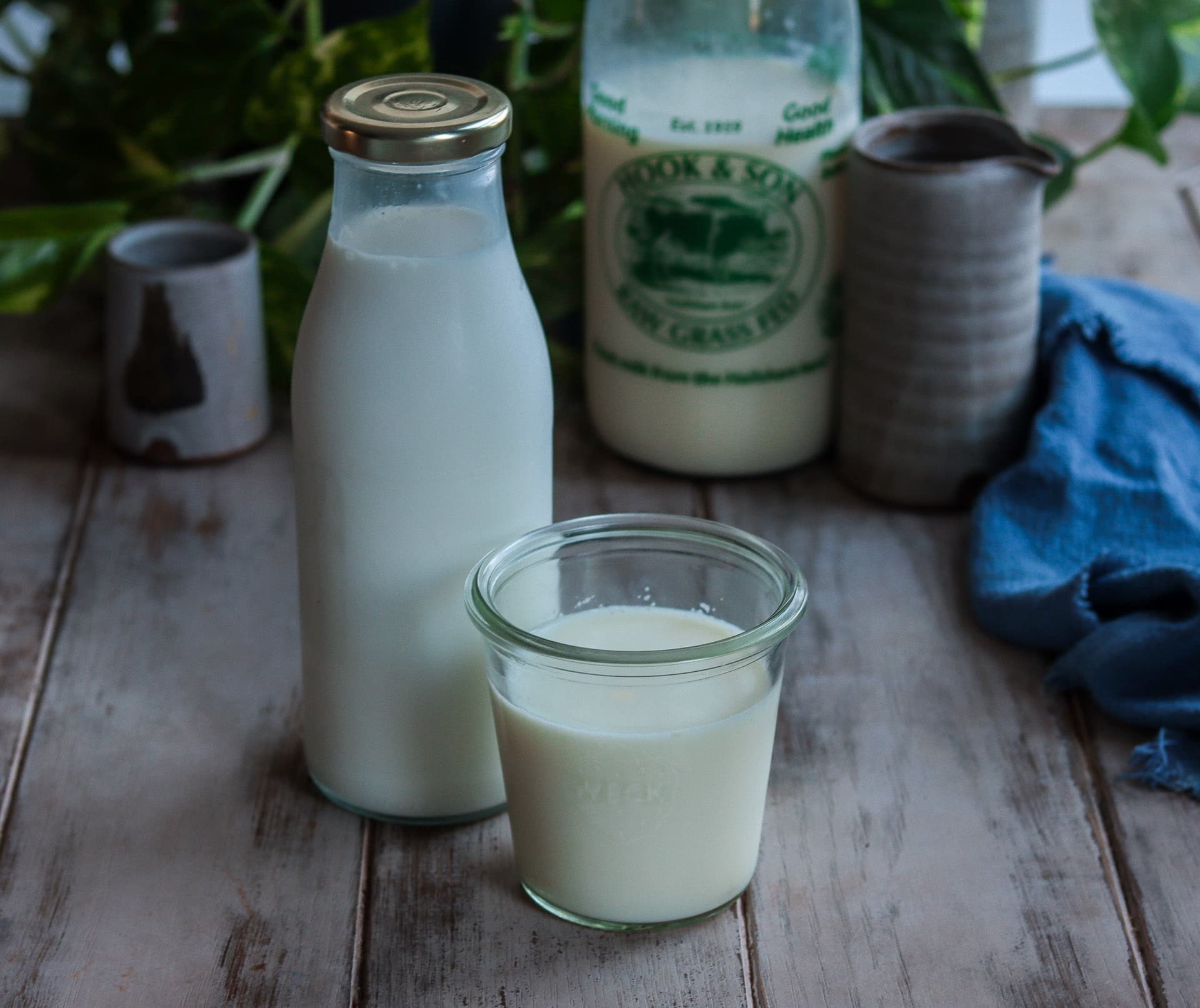 A bottle and glass of homemade kefir on a wooden table