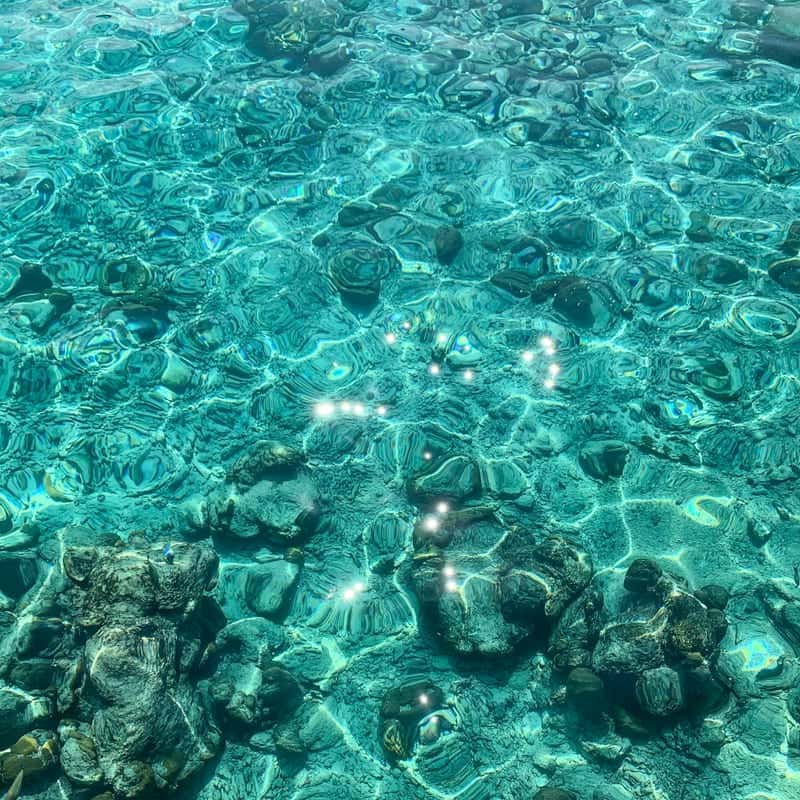 Turquoise sea water over rocks, close up